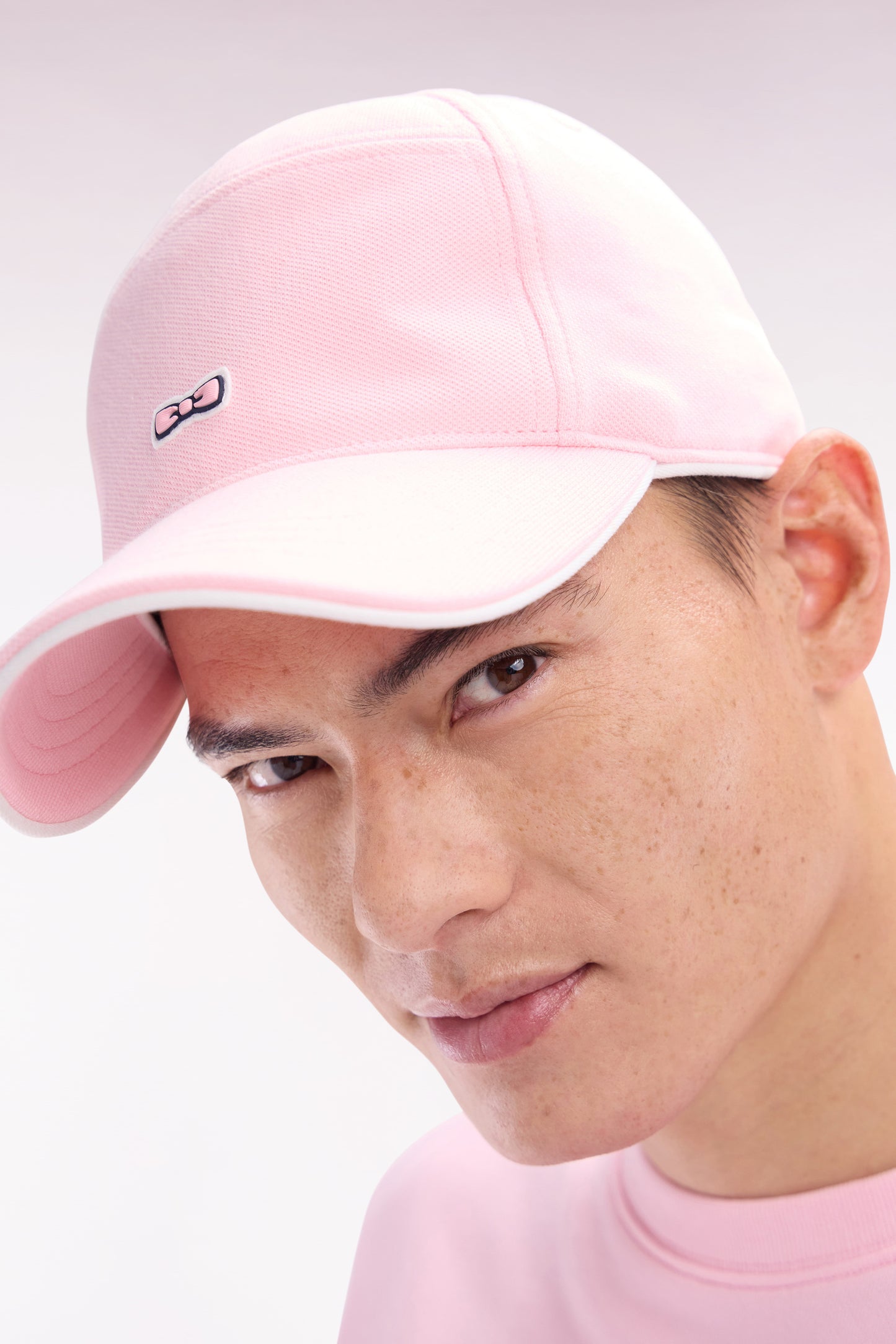 Pink cotton piqué cap with rubber bow tie badge