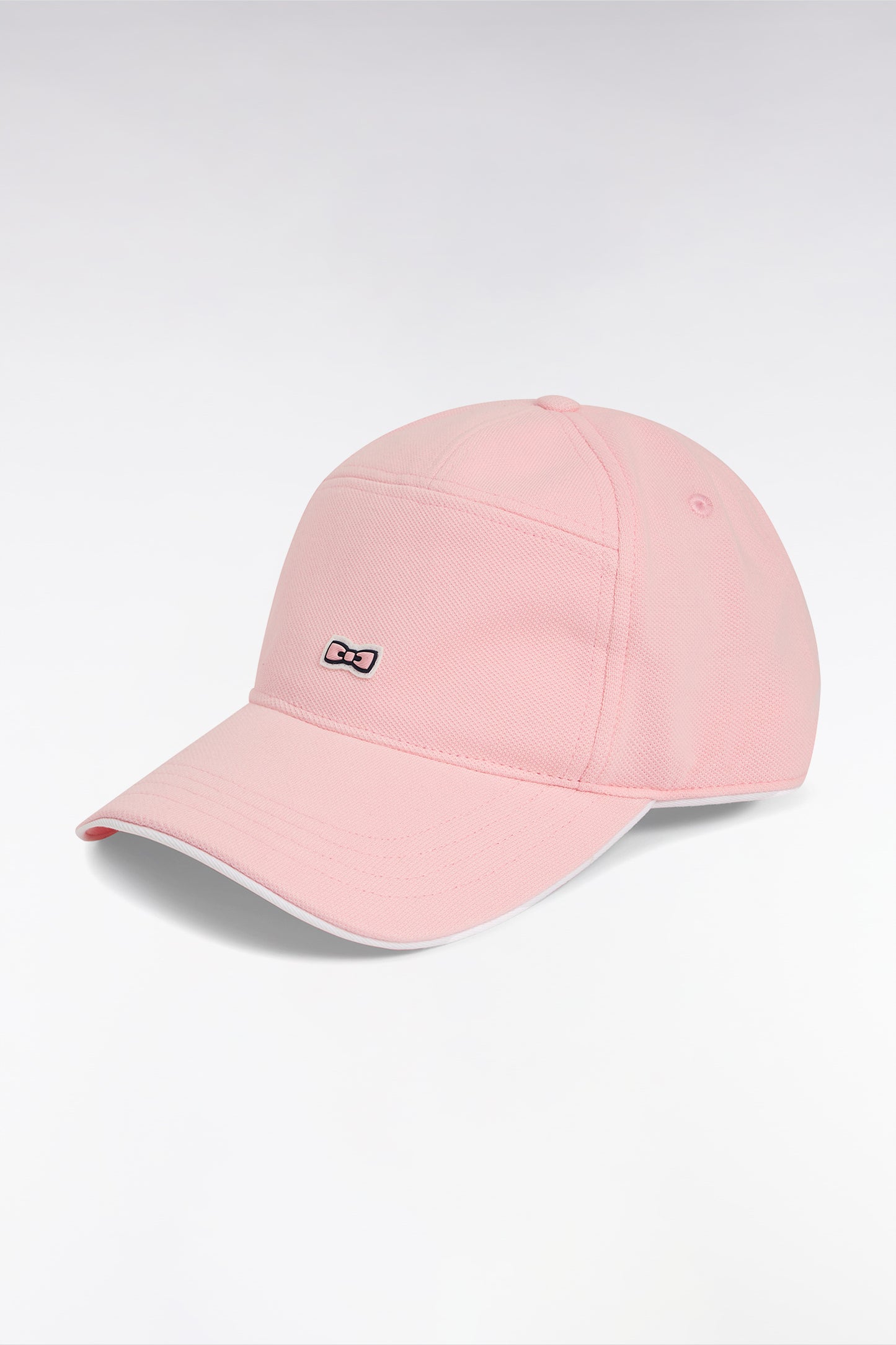 Pink cotton piqué cap with rubber bow tie badge