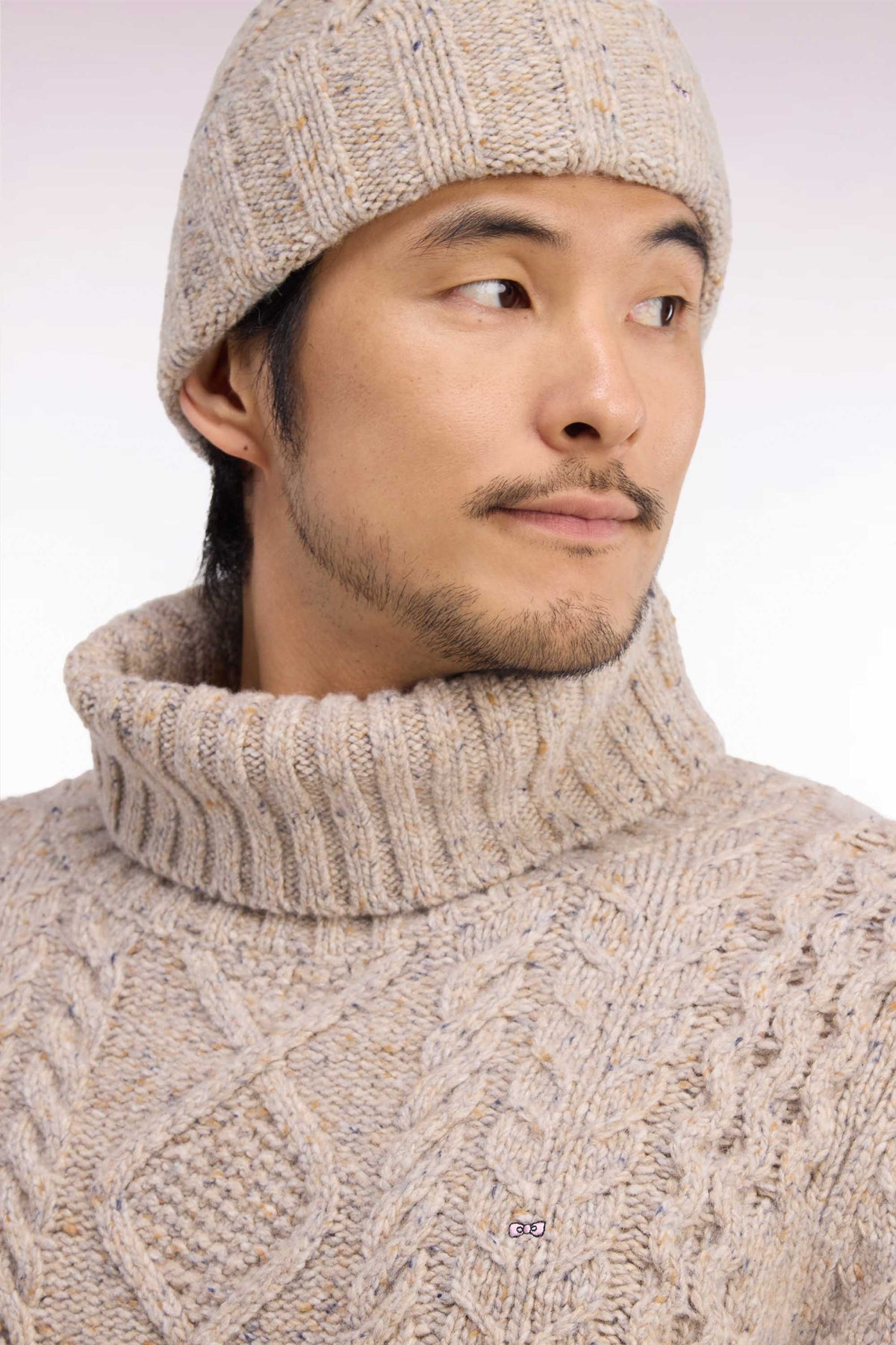 Pull à col roulé en maille torsadée beige coupe droite